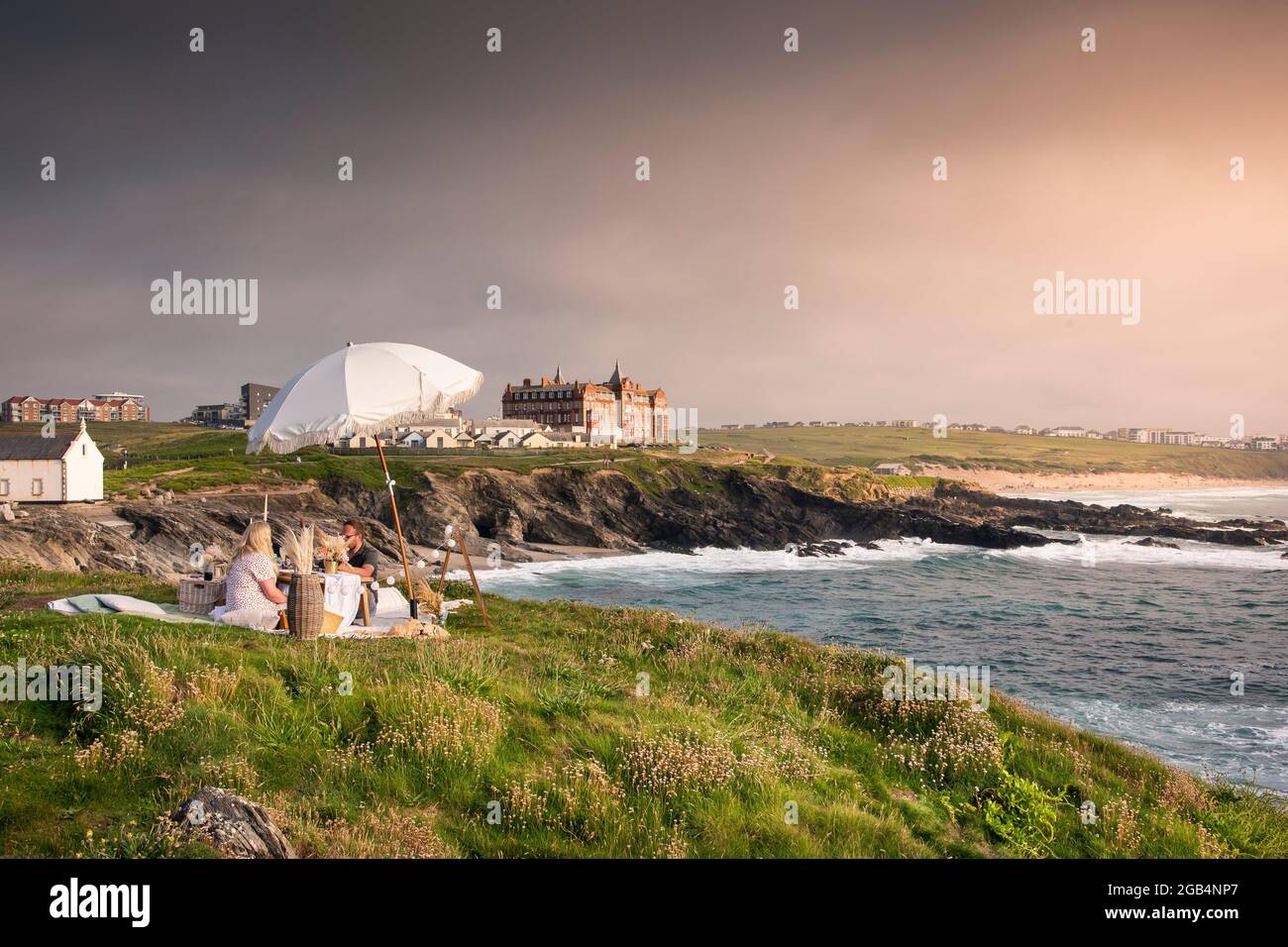 Una coppia che ha un picnic e festeggia un'occasione speciale in stile a Towan Head a Newquay in Cornovaglia. Foto Stock
