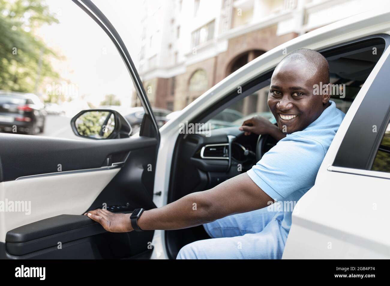 Allegro ragazzo nero che entra in bella automobile Foto Stock