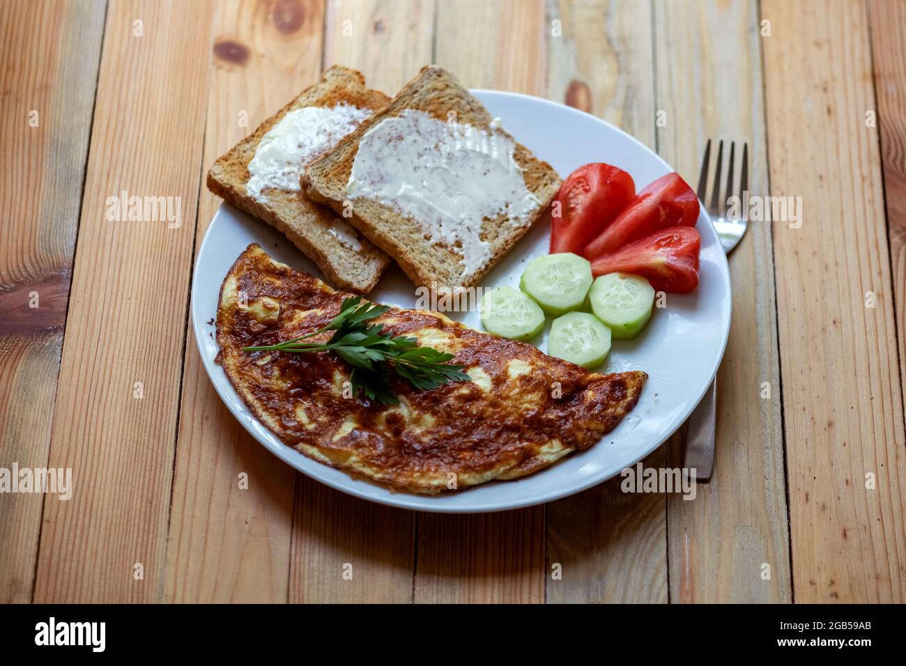 Frittata di formaggio con toast in cucina a casa su tavolo di legno. Fotografia alimentare Foto Stock