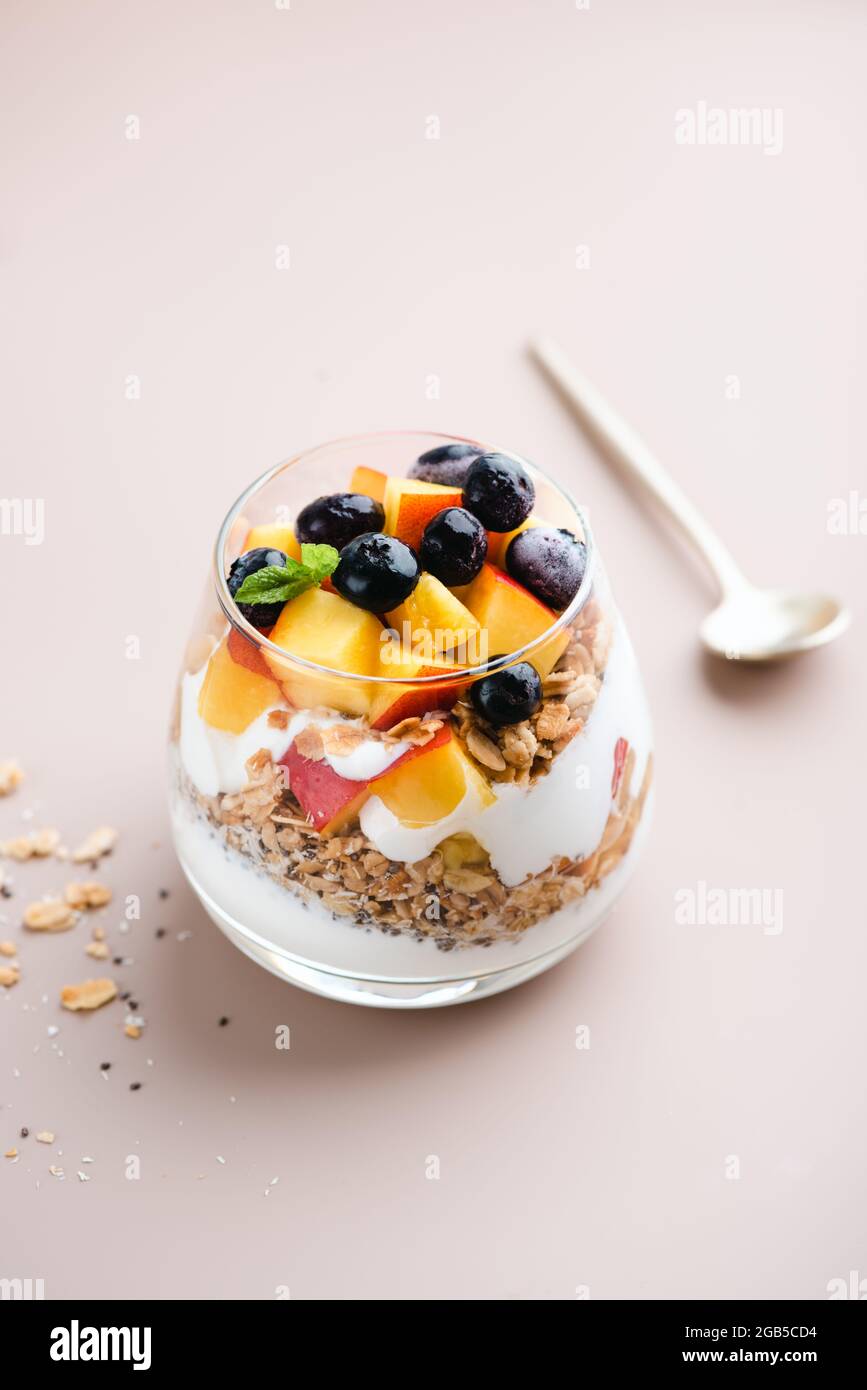 Yogurt alla granola Parfait con frutta in vetro. Colazione o snack a basso contenuto calorico Foto Stock