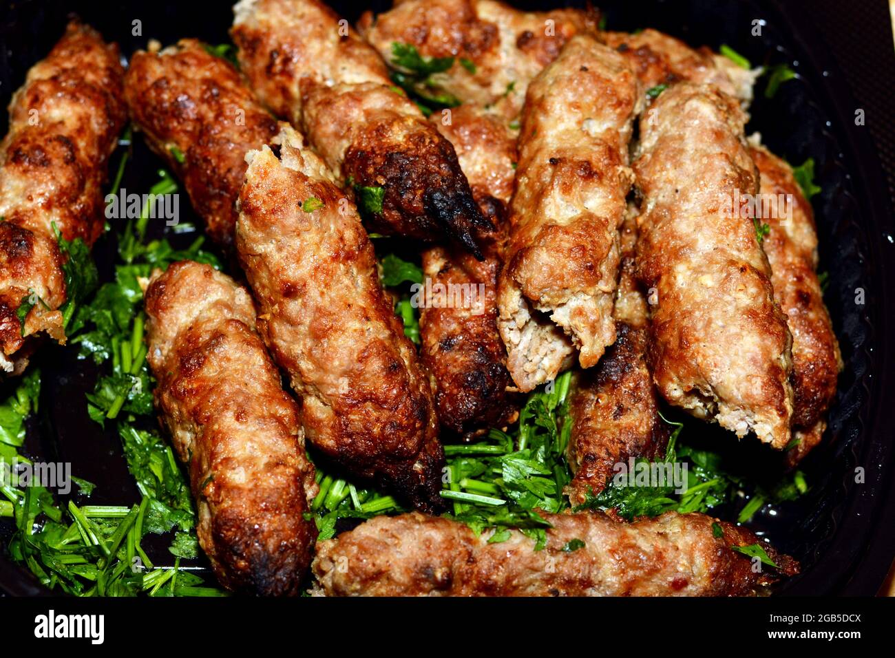 Cucina araba tradizionale cibo di manzo Kofta e carbone kebab alla griglia con prezzemolo verde su di esso, orientale grigliato cibo alla griglia Foto Stock