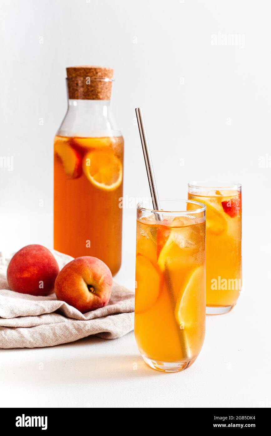 Due bicchieri e una caraffa di tè freddo fatto in casa con pesca. Foto Stock