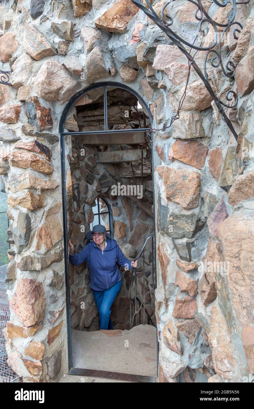 Rye, Colorado - UN visitatore sale una scalinata interna al Castello di Bishop. Il Castello è una elaborata struttura in pietra e metallo e un'attrazione a lato della strada. Foto Stock