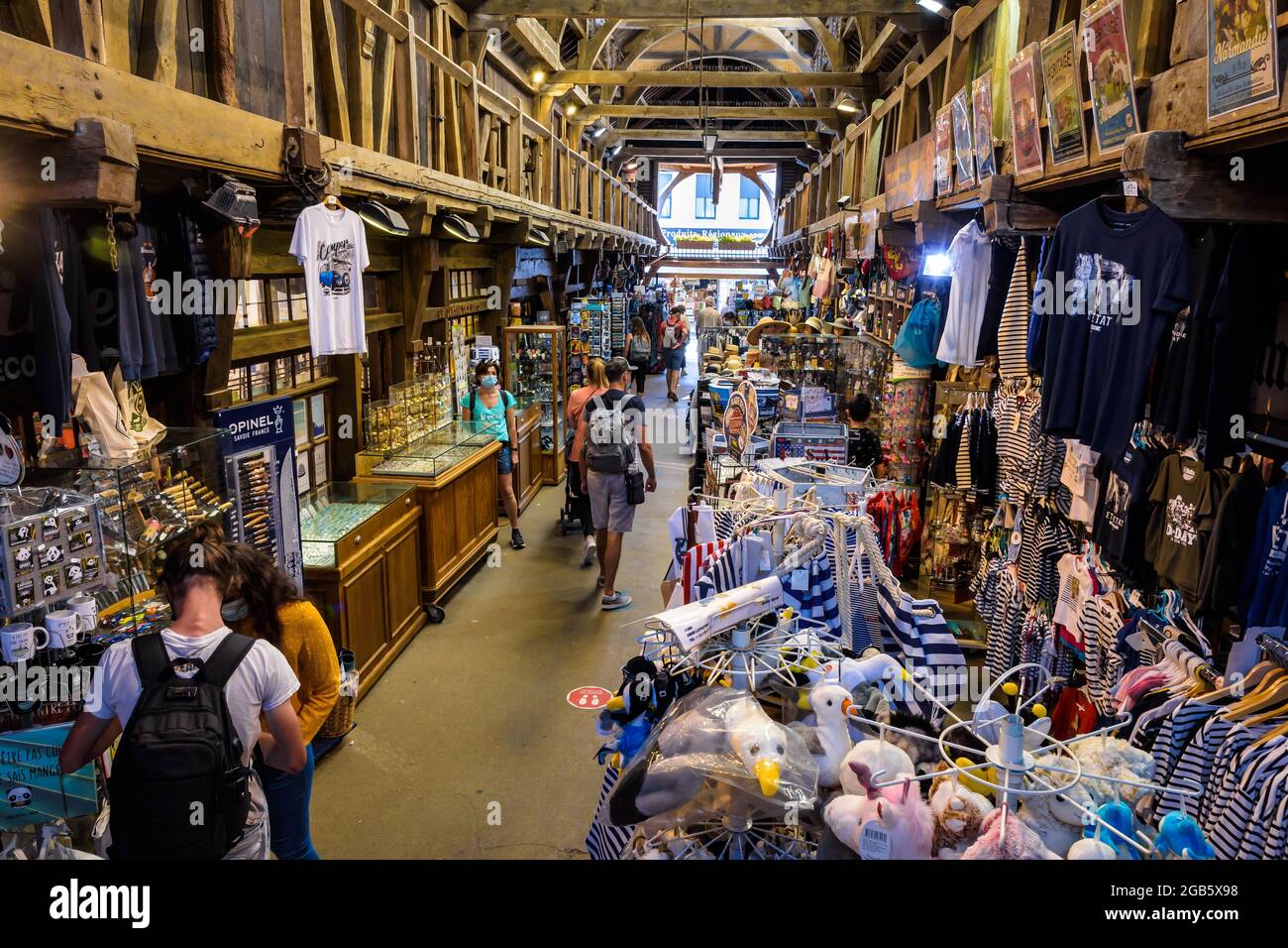 I turisti vanno a fare shopping nel vecchio mercato di Etretat, in Francia, un mercato coperto costruito nel 1927 per le bancarelle di pesce, che oggi ospita negozi di articoli da regalo e negozi di spiaggia Foto Stock