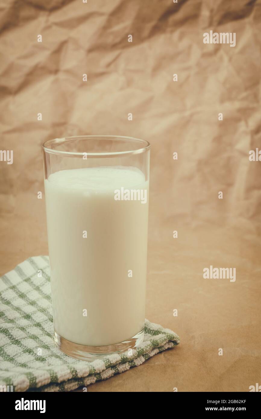 bicchiere di latte su fondo di carta sgualcito Foto Stock