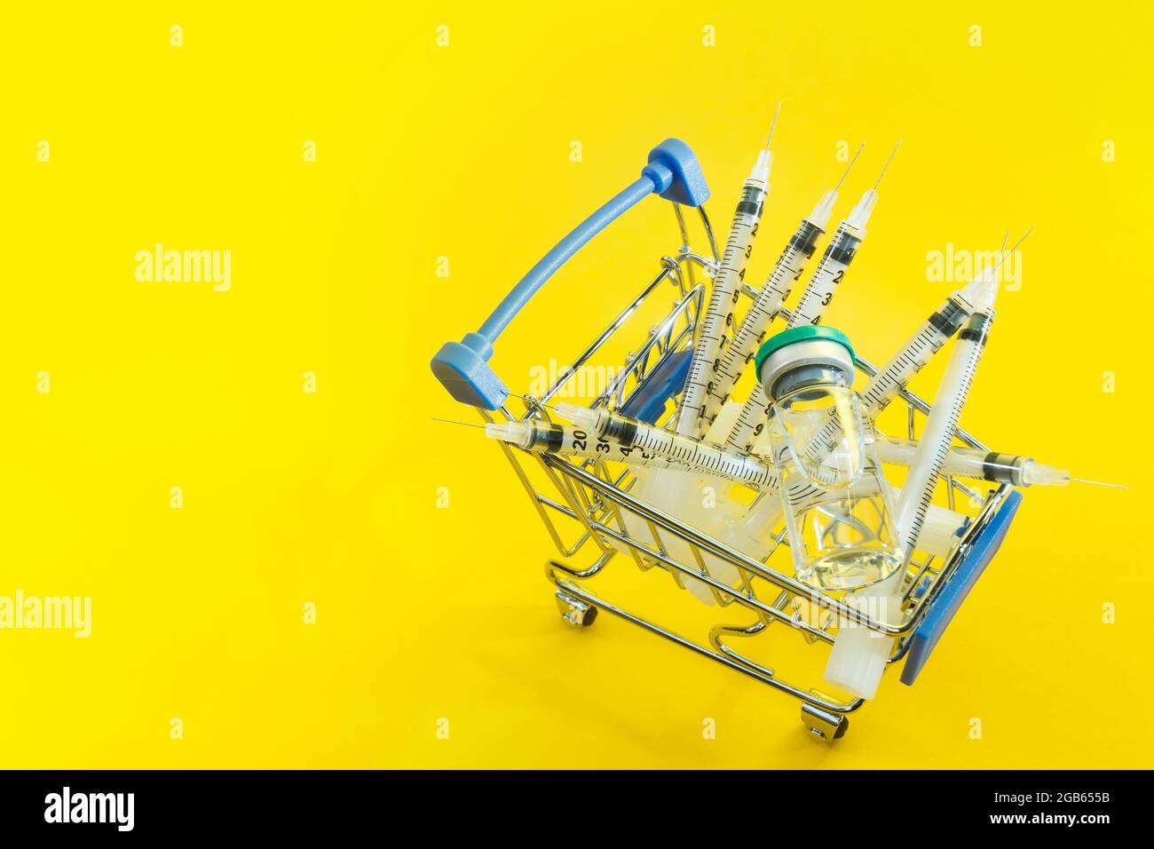 carrello supermercato con siringhe e ampolla su sfondo giallo Foto stock -  Alamy