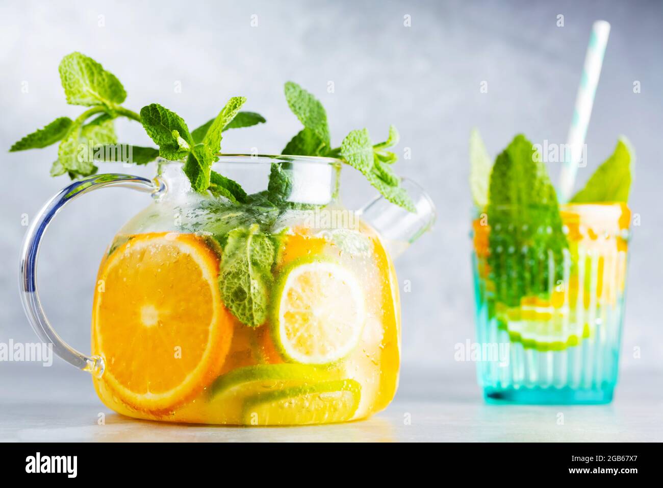 Disintossicare la bevanda di limonata di acqua, limone, arancia e foglie di  menta in una teiera trasparente. Cocktail al tè freddo alla menta. Bevanda  fresca estiva. Spazio di copia Foto stock -