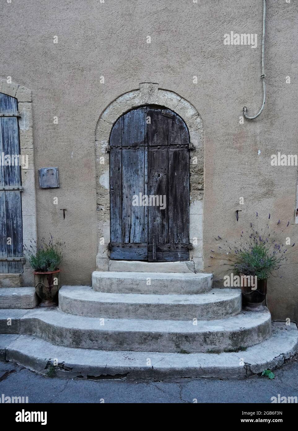 Vecchia porta di legno nella città vecchia, vasi di lavanda, Lourmarin, Provenza, Francia Foto Stock