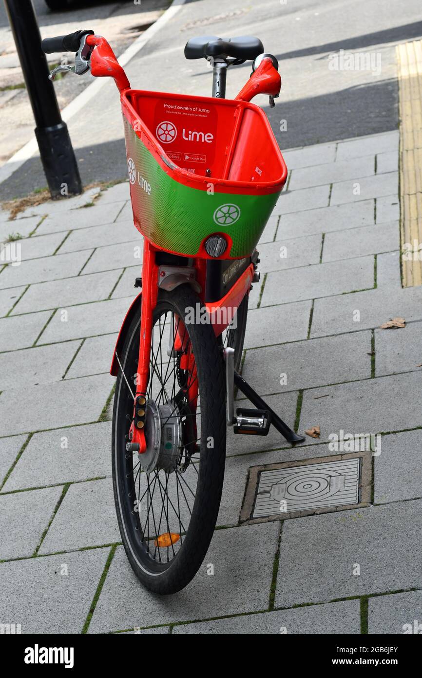 Londra, Inghilterra, un'irreabile bici elettrica di assistenza Lime e da calce e uber su un marciapiede lastricato Foto Stock