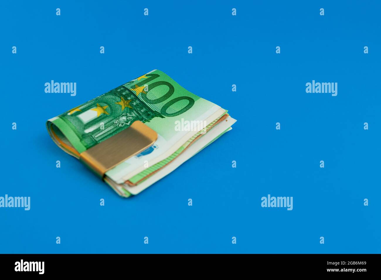 Clip con banconote in euro su sfondo blu Foto Stock