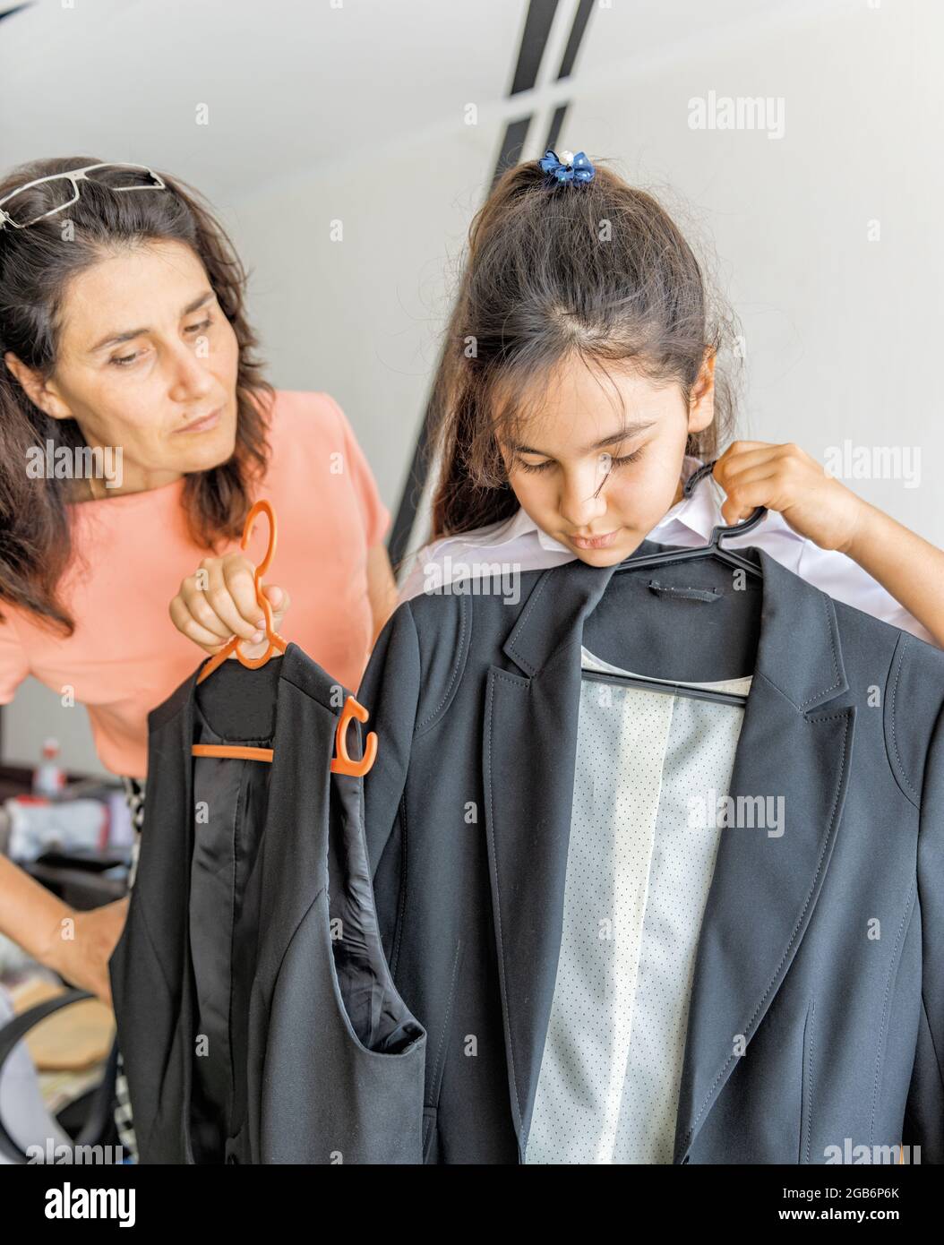 una studentessa cerca un nuovo vestito per la scuola Foto Stock