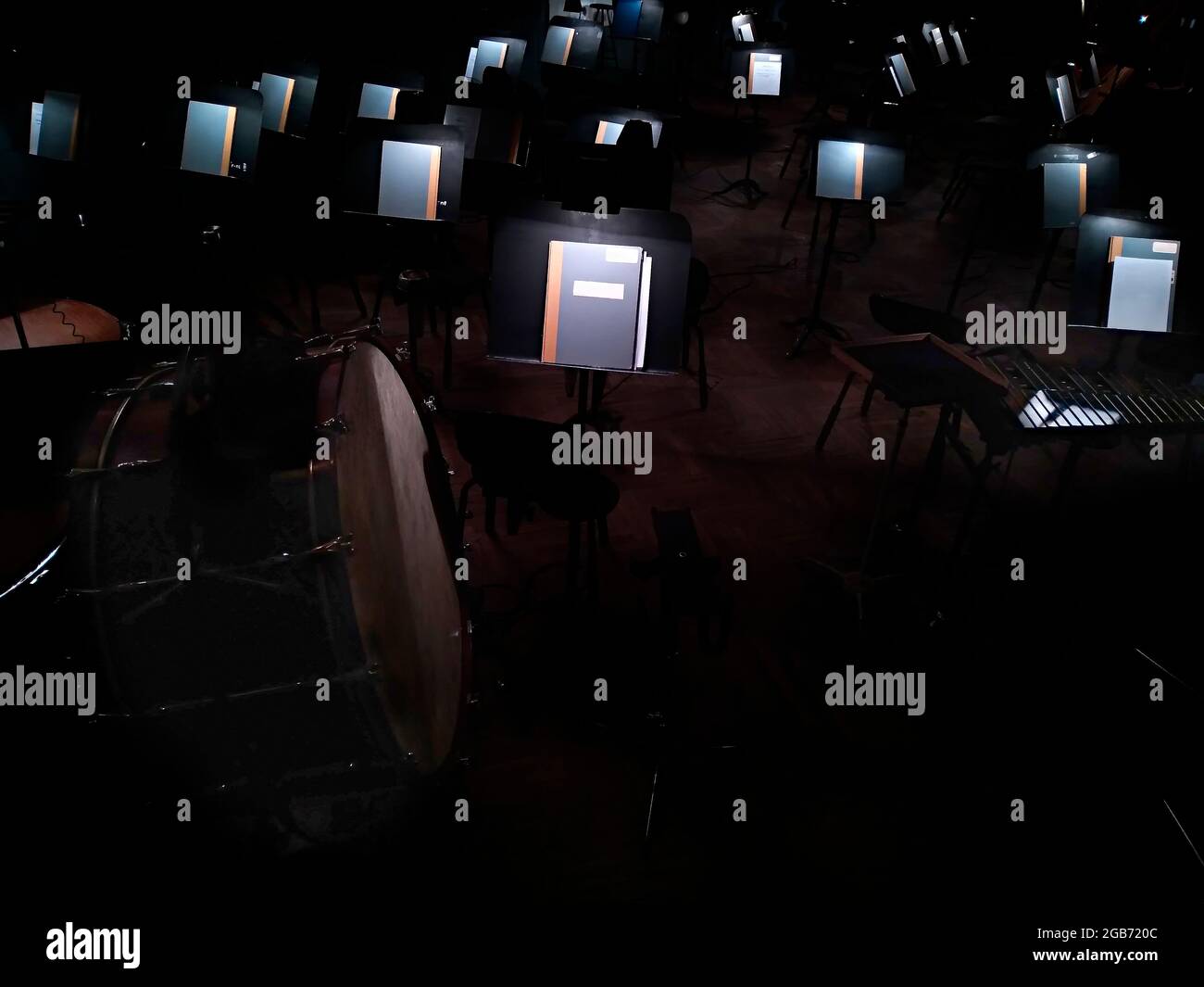 la musica si erige con spartiti di musica illuminata di un balletto o di un'opera e sedie nella fossa dell'orchestra Foto Stock
