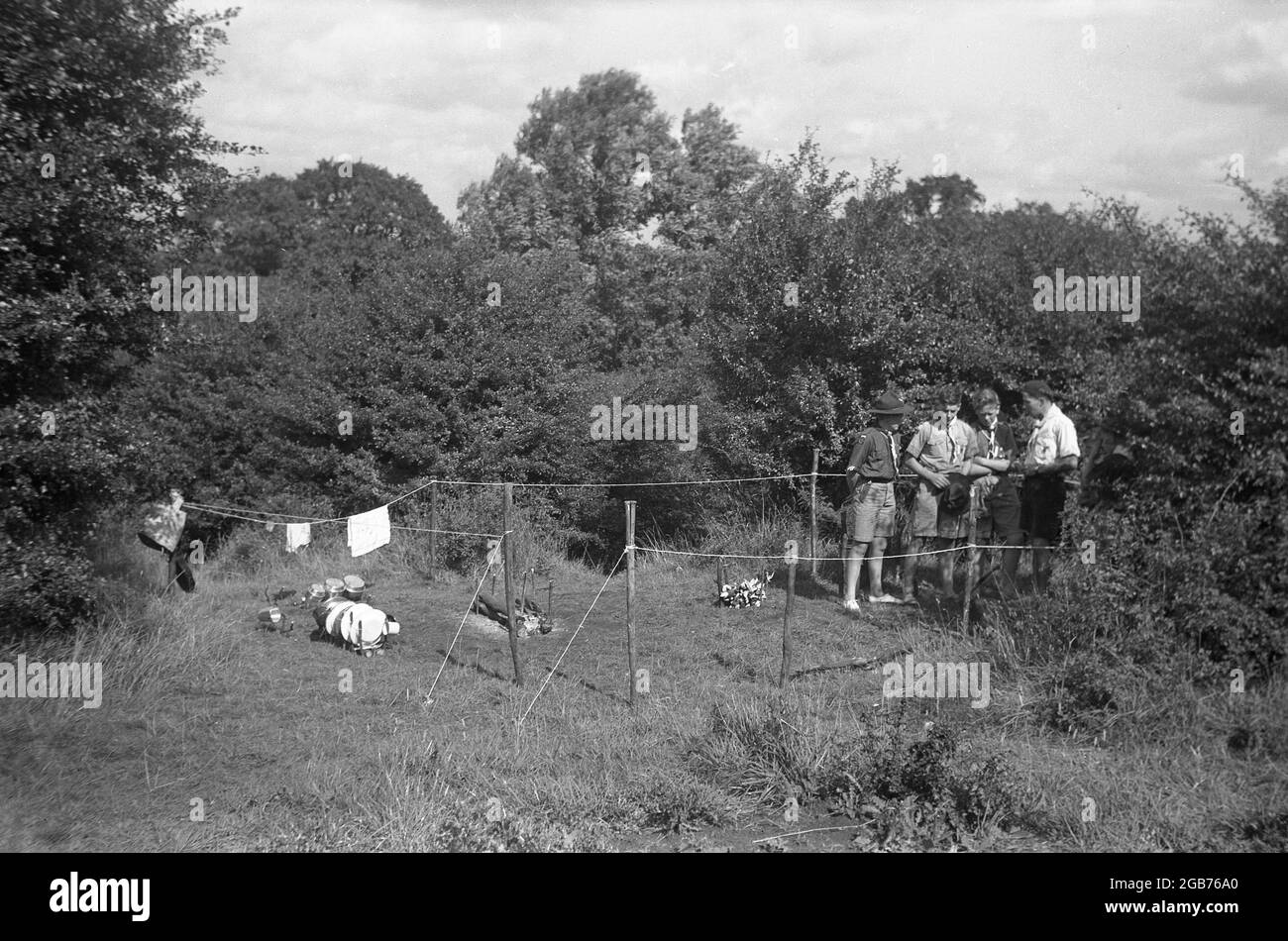 1951, storico, un'ispezione da parte di un maestro scout dei preparativi per l'area di cottura del campo scout, segnato al bordo della foresta Inghilterra, Regno Unito. Foto Stock