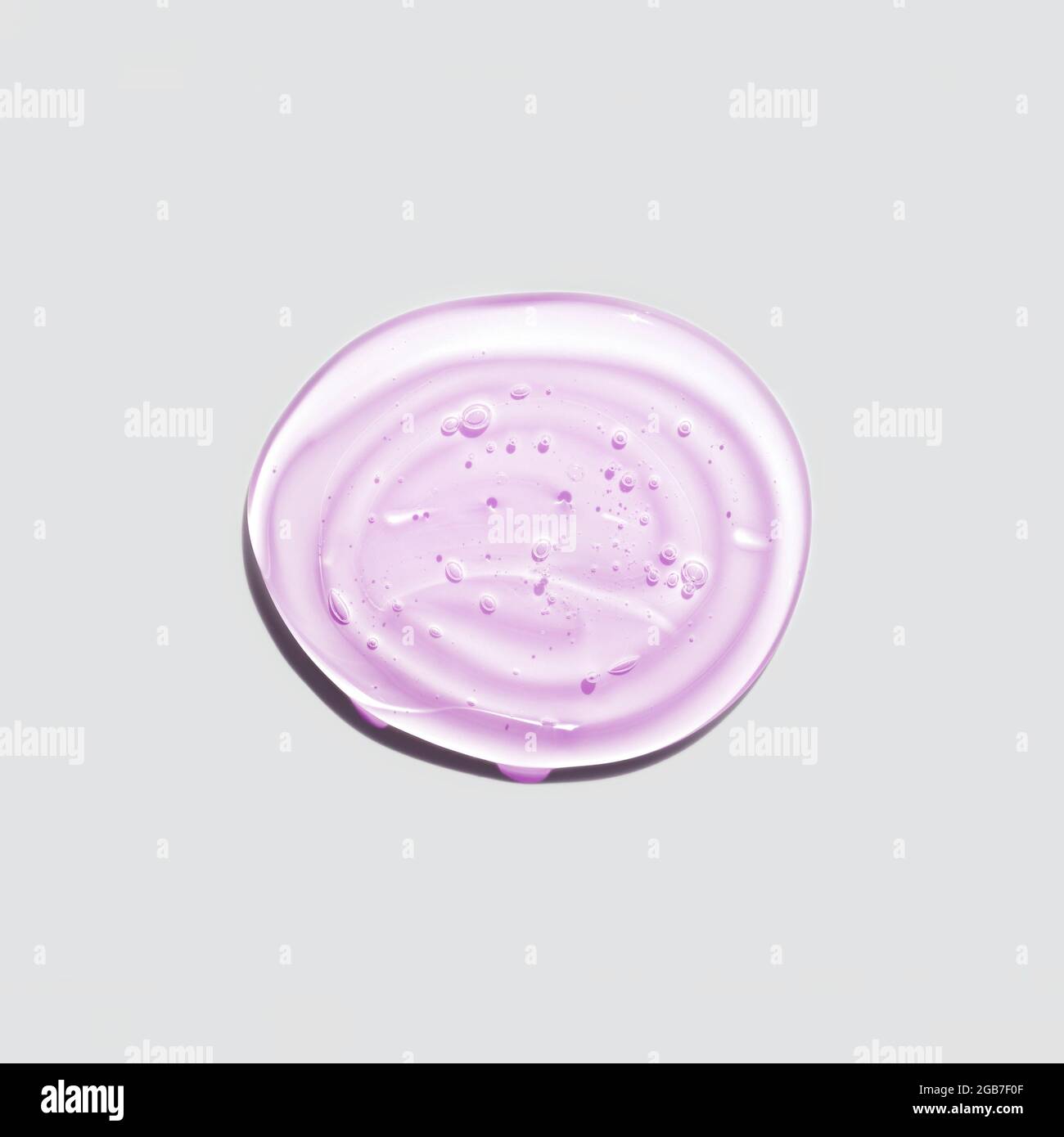 Gocce di gel rotonde rosa trasparente isolate su sfondo bianco. Vista dall'alto. Protezione da virus o concetto cosmetico. Primo piano della texture del siero del volto. Foto Stock