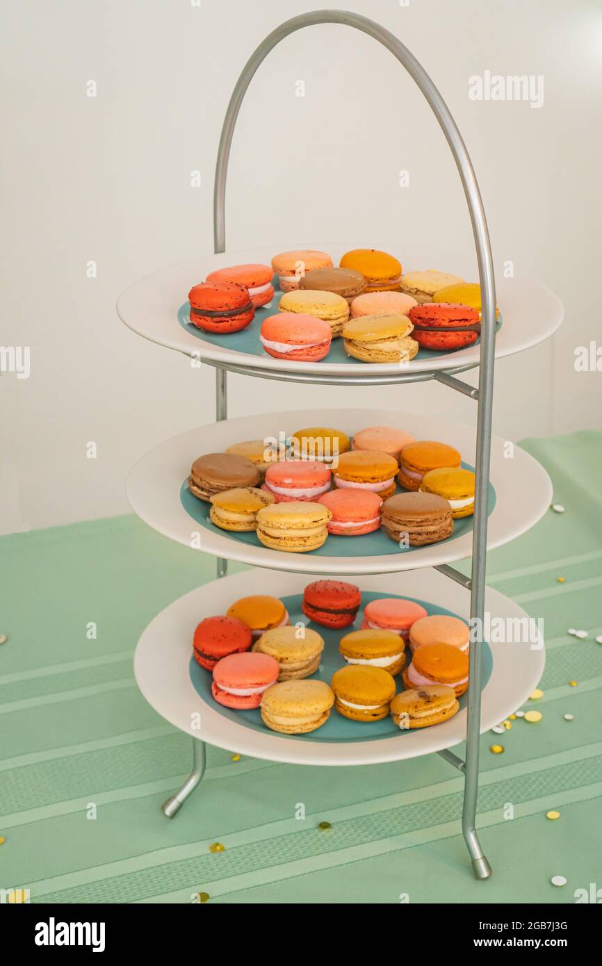 Tre livelli di piatti pieni di colorati dolci francesi Macaron per dessert Foto Stock