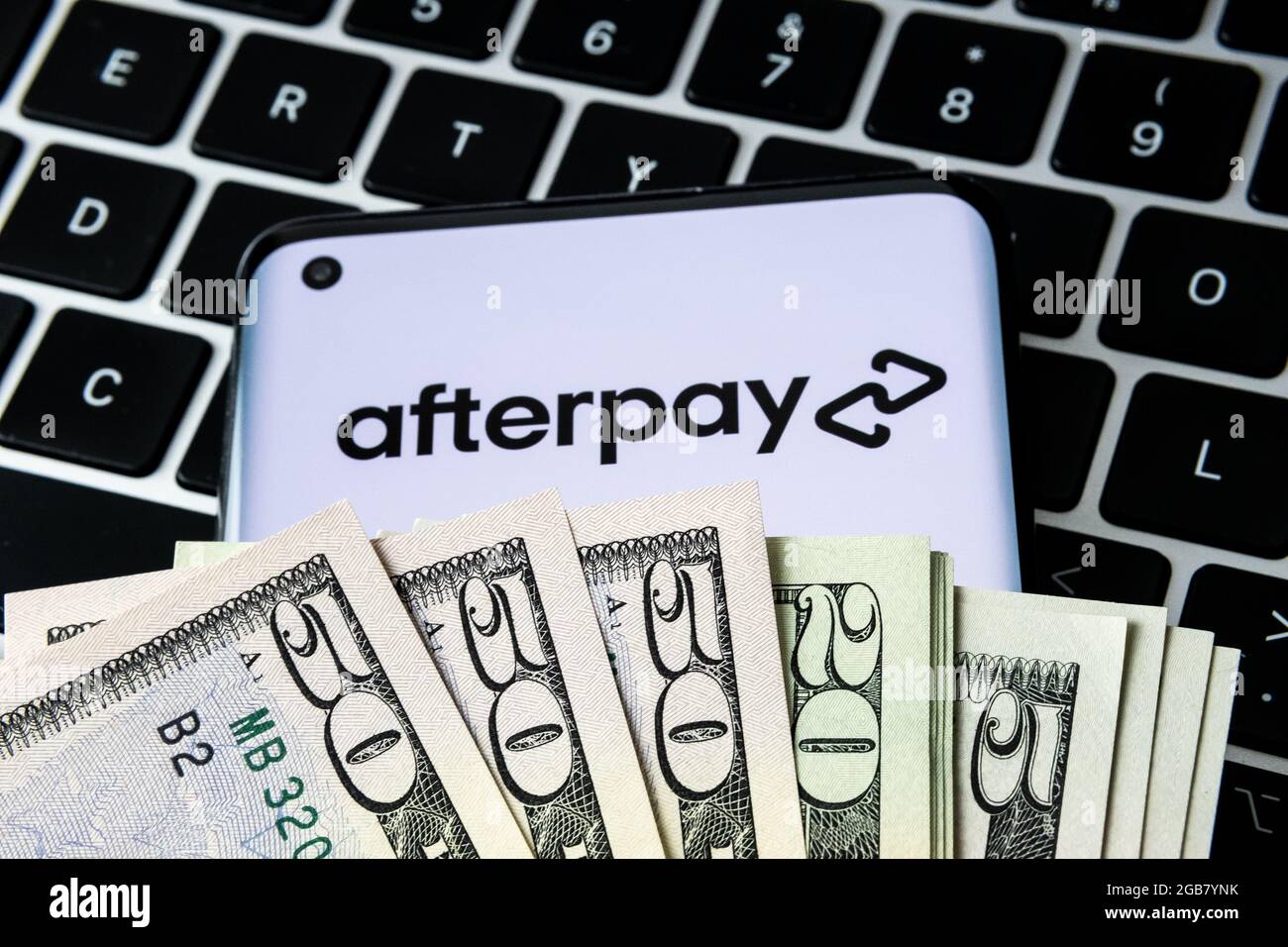 Logo aziendale Afterpay visto su smartphone coperto da dollari e collocato sulla tastiera. Acquista ora paga più tardi azienda. Stafford, Regno Unito, 2 agosto 2 Foto Stock