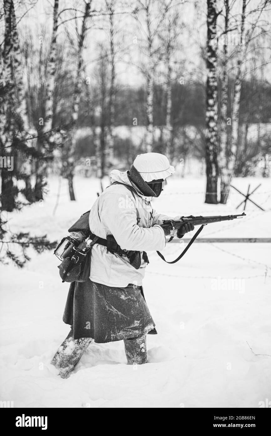 Tedesco Wehrmacht Soldato fanteria nella seconda guerra mondiale attaccando con Rifle nel giorno d'inverno. Rievocazione storica. SECONDA GUERRA MONDIALE. Foto in bianco e nero Foto Stock