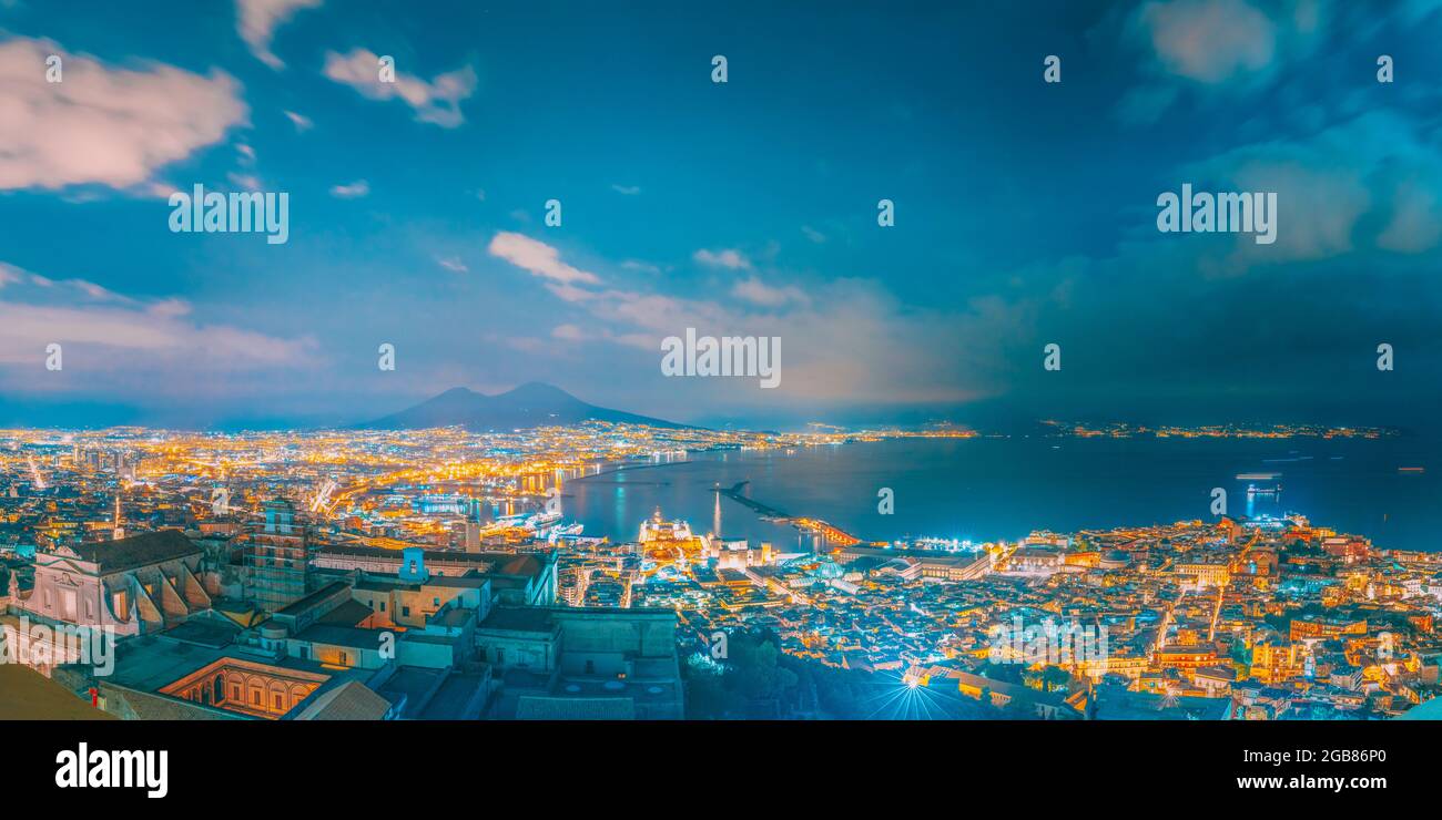 Napoli, Italia. Skyline Cityscape In illuminazione serale. Mar Tirreno e del paesaggio con il vulcano Vesuvio. Città in illuminazione notturna Foto Stock