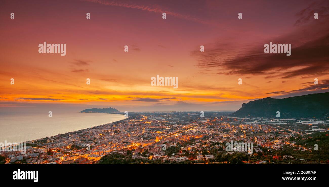 Terracina, Italia. Vista dall'alto skyline città in serata Tramonto. Illuminazioni cittadine Foto Stock