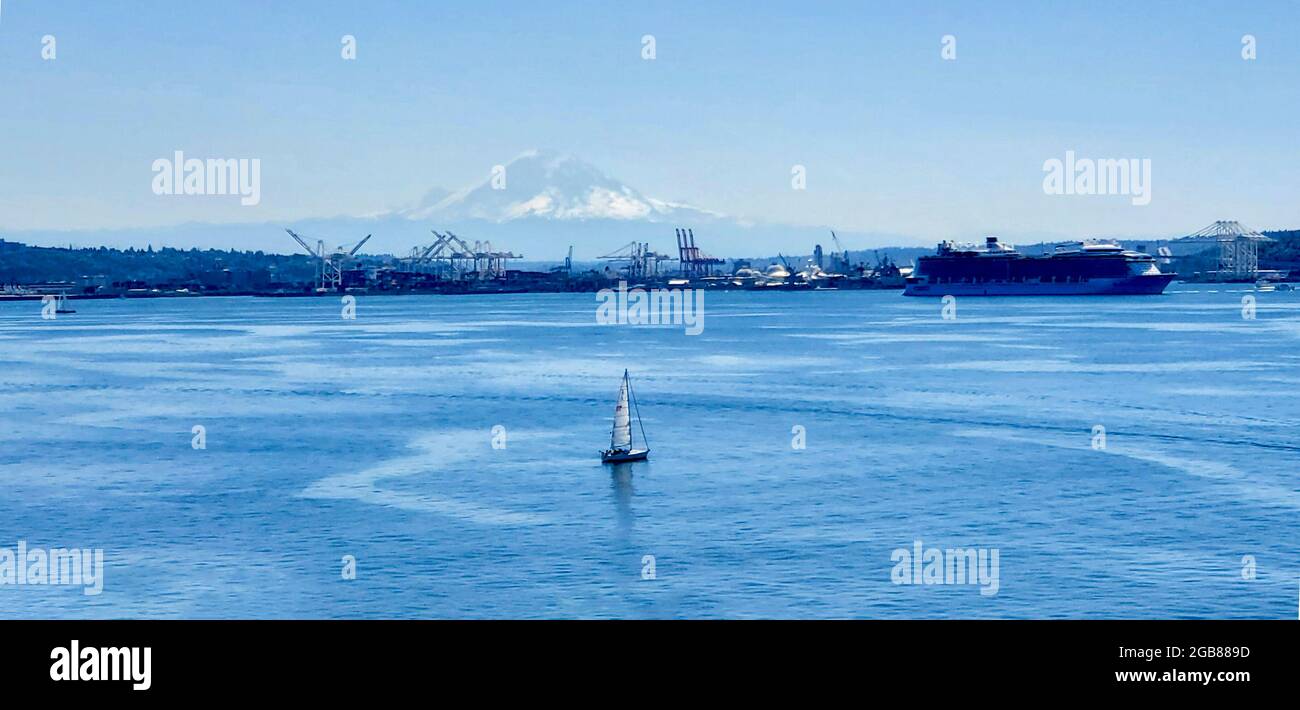 Mt. Rainier in lontananza con la barca a vela. Vista dal molo 91 di Seattle. Foto Stock