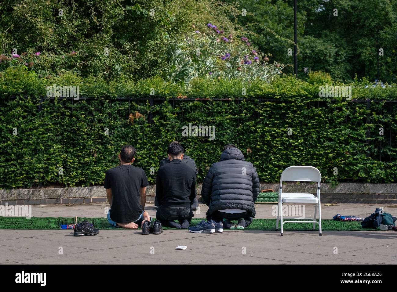 I musulmani prendono le preghiere di mezzogiorno la domenica vicino all'entrata di Hyde Park, Londra, Regno Unito. Foto Stock