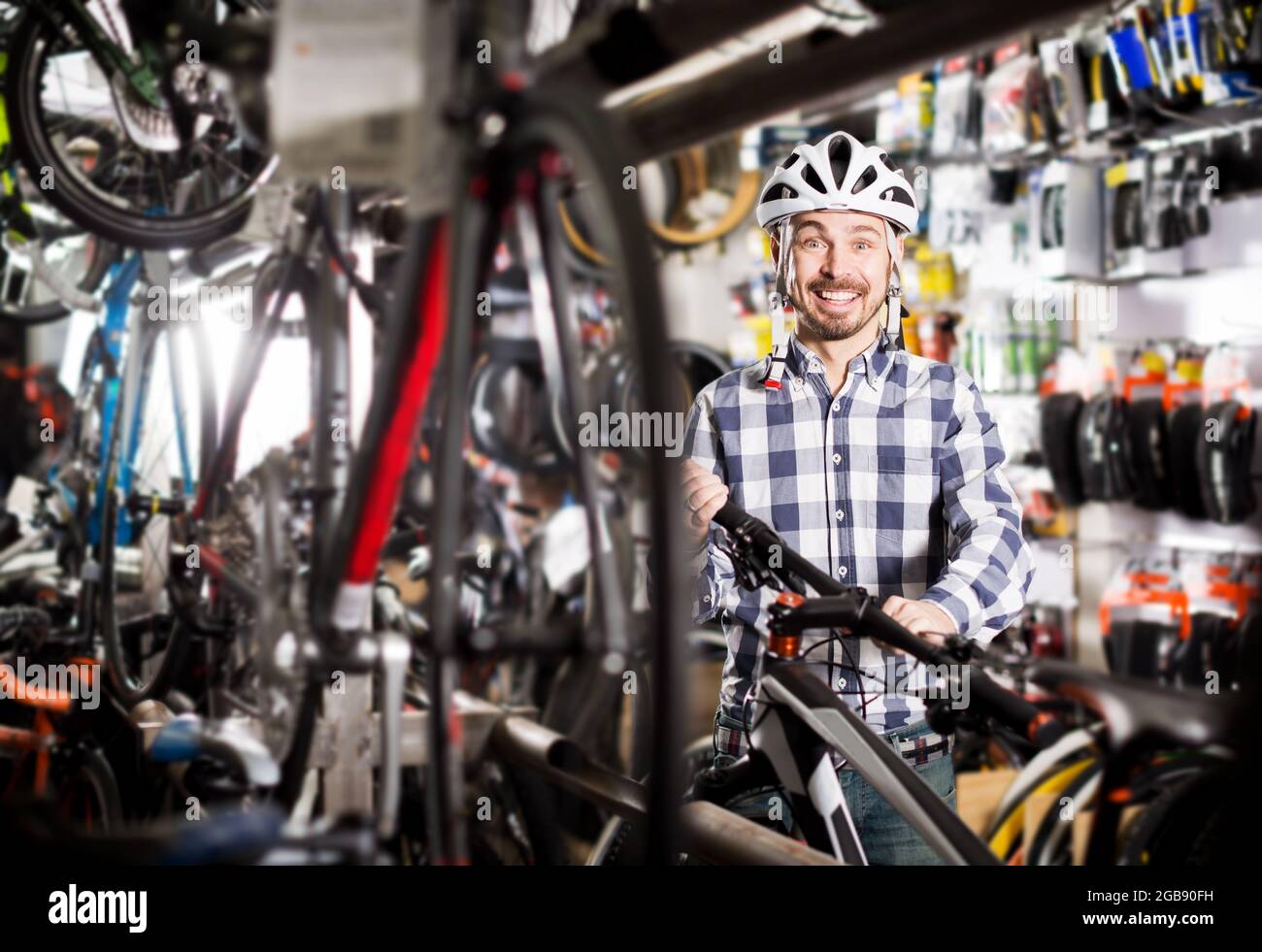 L'uomo in casco sceglie una comoda bicicletta Foto Stock L'uomo in casco sceglie una comoda bicicletta Foto Stock