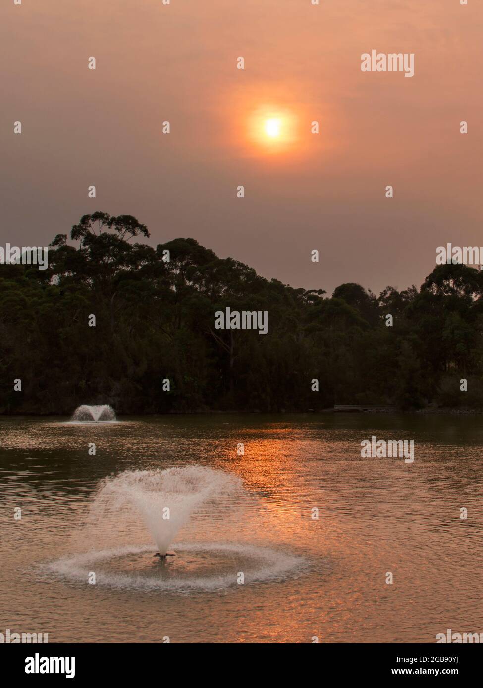 un tramonto su un corpo d'acqua con fontane d'acqua Foto Stock