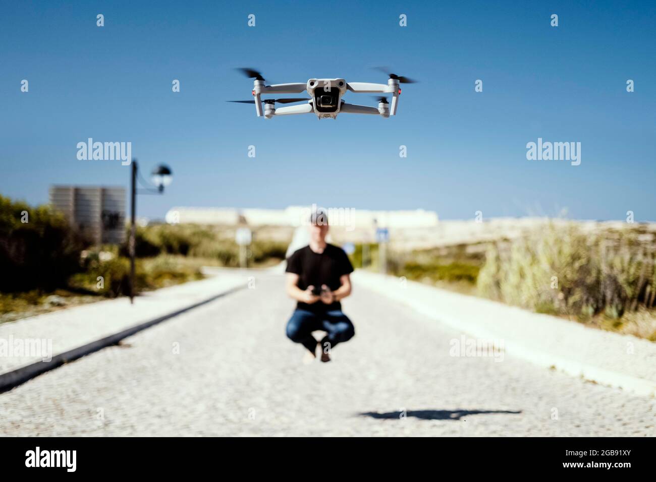 Uomo che tiene in volo remoto insieme al suo drone in primo piano Foto Stock