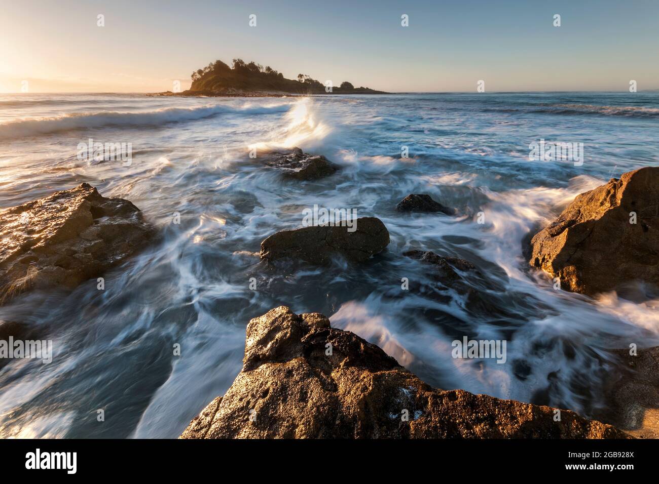 rocce e acqua con un'isola al sole del mattino Foto Stock