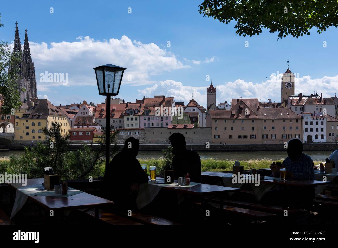 Vista sulla città con la Cattedrale di San Pietro, di fronte alla birreria all'aperto con gli ospiti come silhouette, Ratisbona, Palatinato superiore, Baviera, Germania Foto Stock