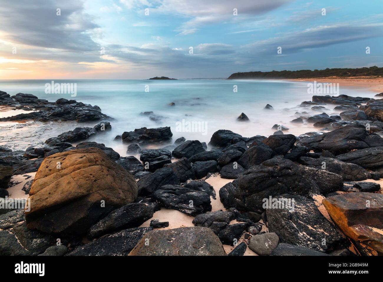 rocce e acqua blu sulla costa Foto Stock
