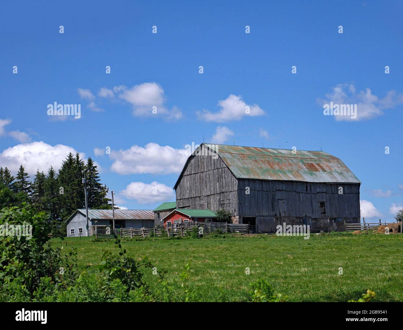 Vecchio fienile in legno in una fattoria in una giornata estiva soleggiata Foto Stock