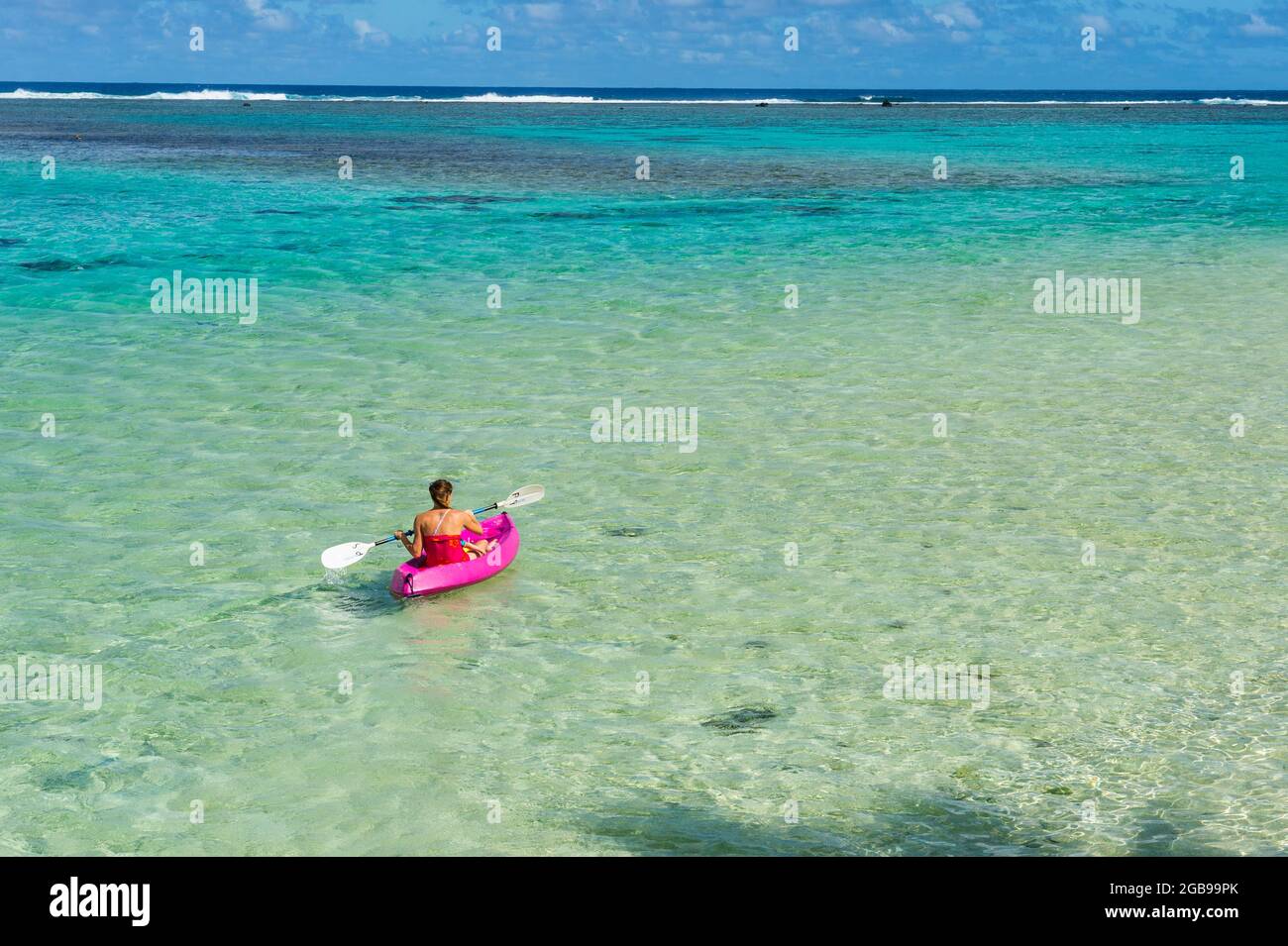 Donna kayak nelle acque turchesi di Rarotonga, Rarotonga e delle isole Cook Foto Stock