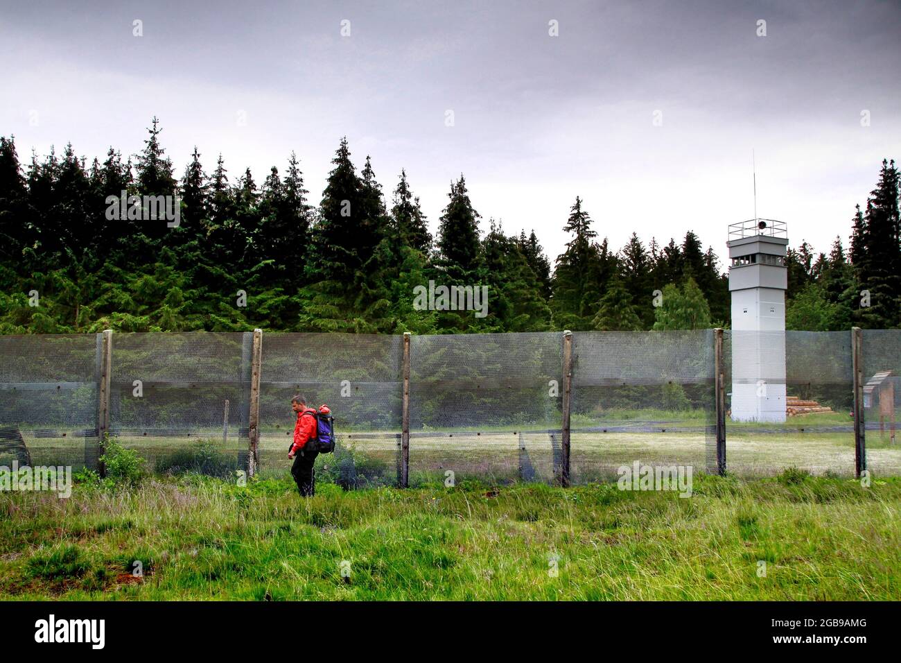 Escursionista, uomo con zaino all'ex confine tedesco-tedesco, barriera di confine con torre di osservazione delle truppe di confine della RDT, torre di guardia di confine Foto Stock