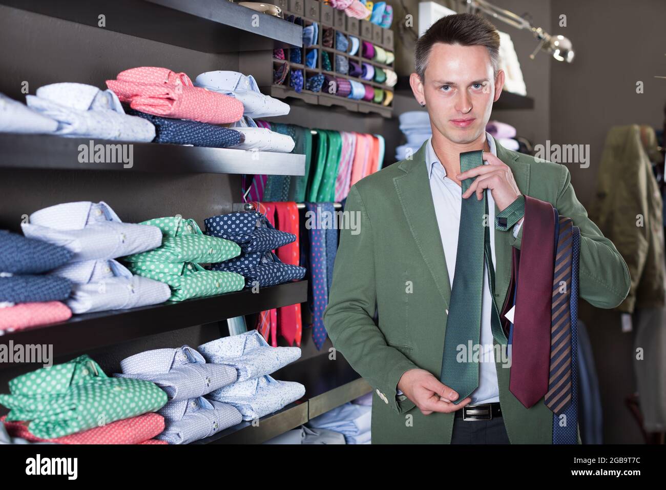 Cliente che esamina le cravatte nel negozio di panni maschili Foto Stock