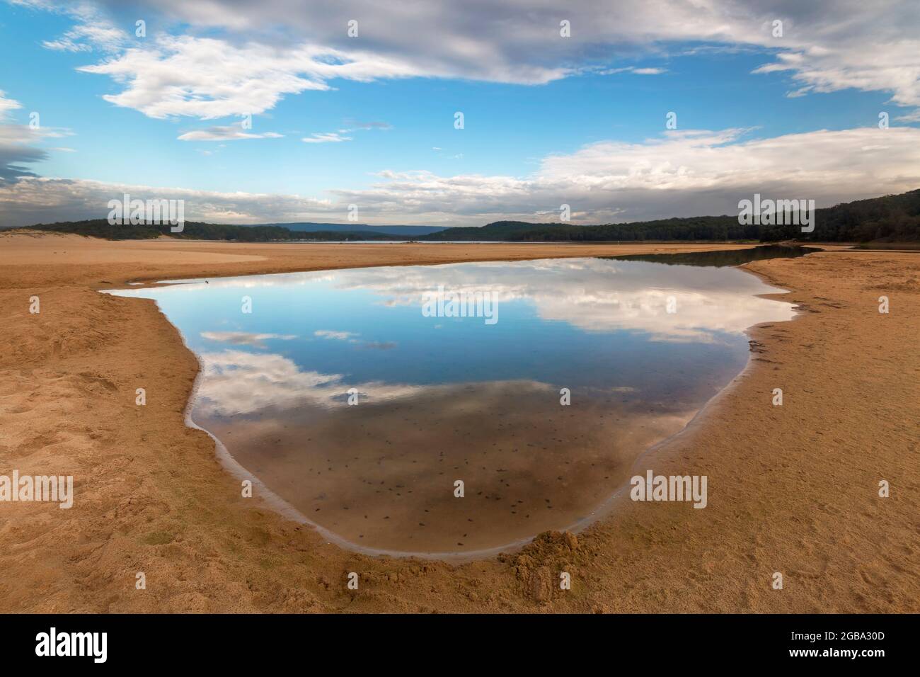 una vista di una spiaggia accanto ad un corpo d'acqua riflesso Foto Stock