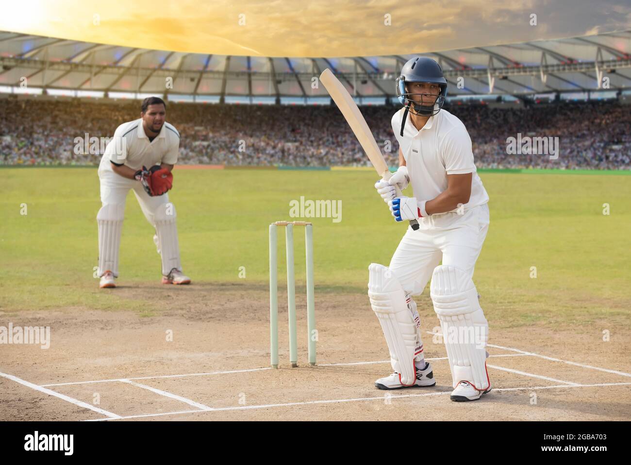 battsman, il cricketer, alla piega, in attesa della palla. Foto Stock