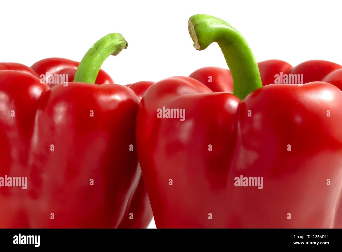 Due peperoni rossi con steli verdi da vicino Foto Stock