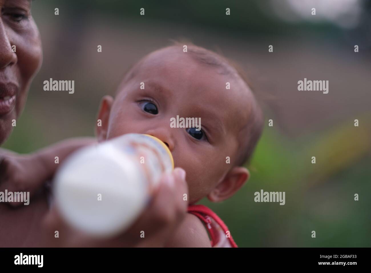 La nonna tailandese alimenta la nipote con il composto di latte Foto Stock