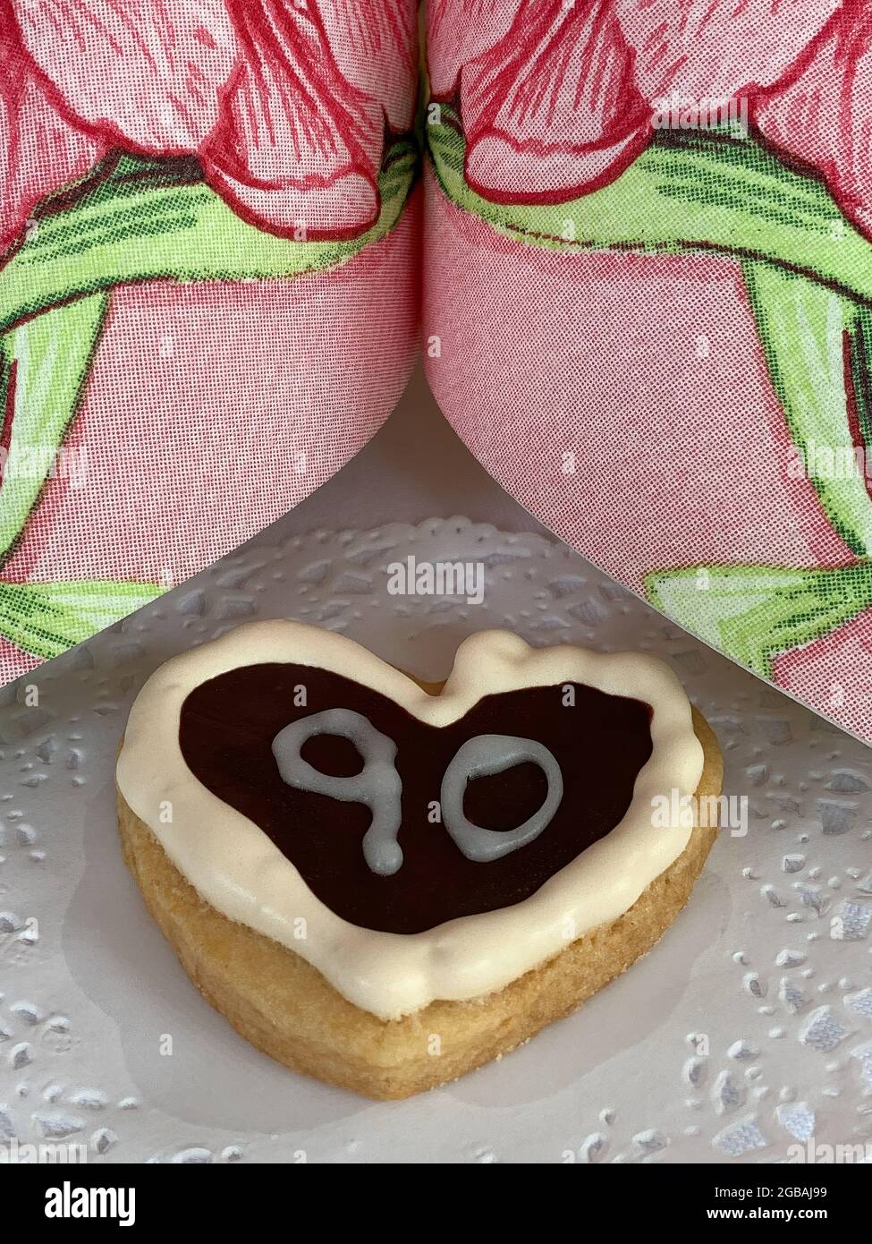 Biscotto a forma di cuore con il numero 90 - un dessert per un novantesimo compleanno Foto Stock