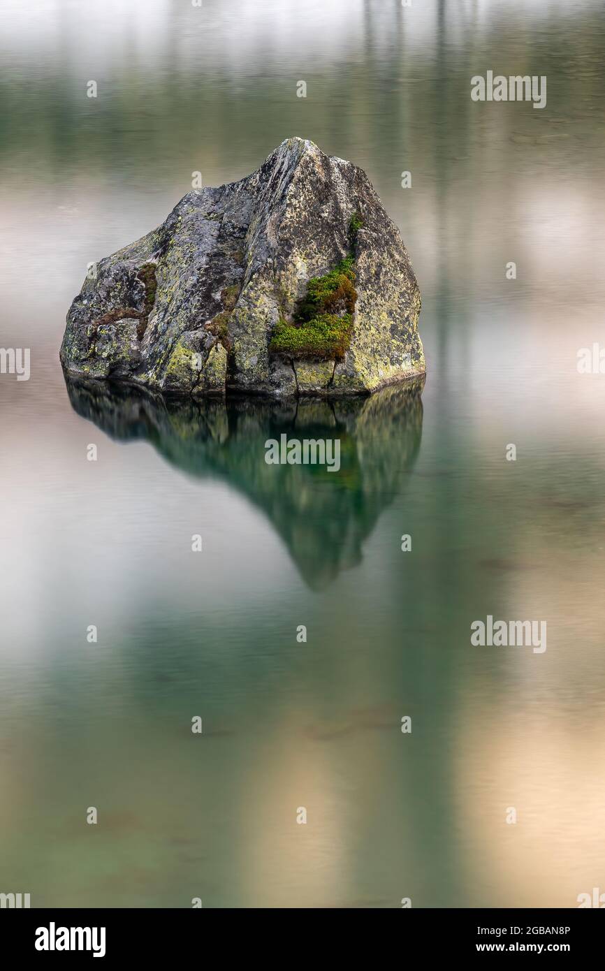 Lunga padronanza di una roccia nel lago di montagna passo Julierpass in Svizzera Foto Stock