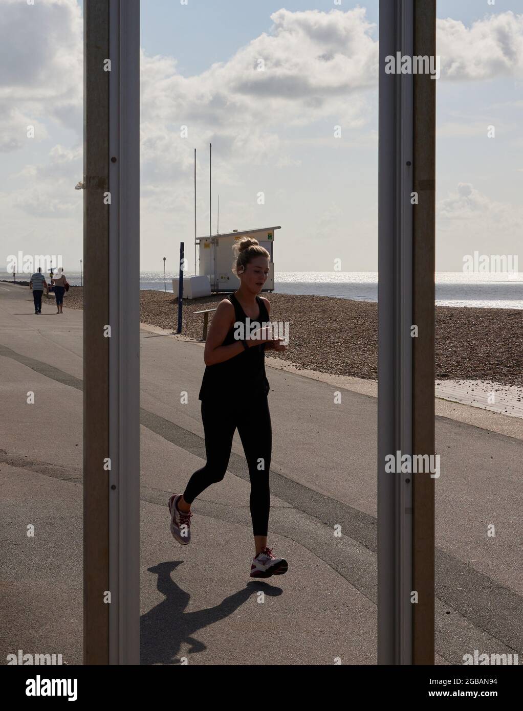 Donna vista correre lungo il lungomare di Bognor Regis. Foto Stock