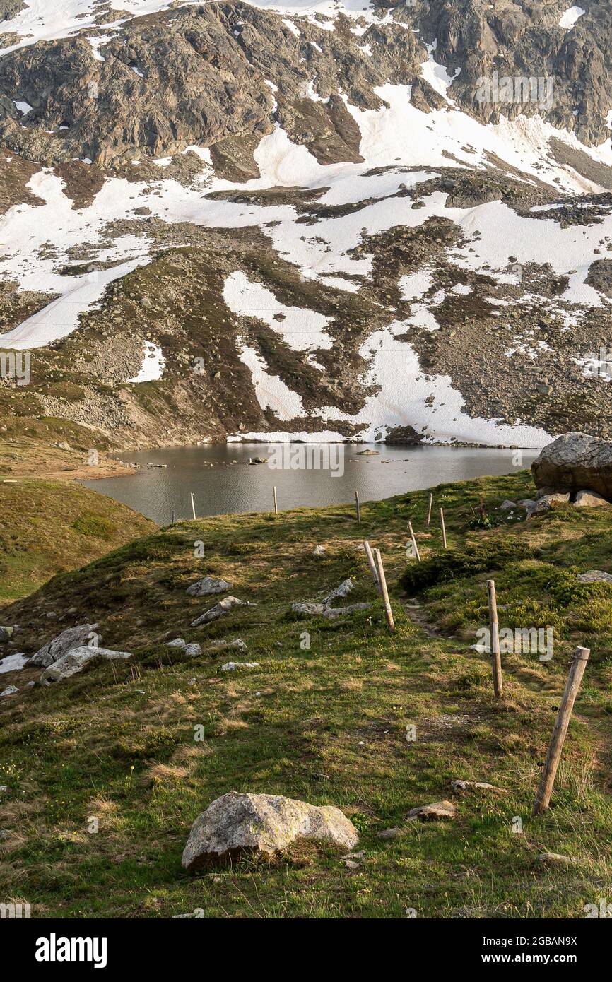 Rocce innevate e il lago in cima al passo di Julier in Svizzera Foto Stock