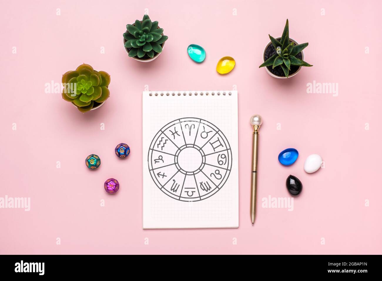 Cerchio oroscopo con dodici segni di zodiaco su carta, dadi divination, pietra colorata su sfondo rosa Fortune raccontare e astrologia predizioni Foto Stock