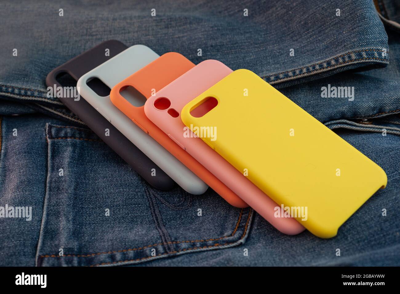 custodia per cellulare multicolore su sfondo in denim Foto Stock