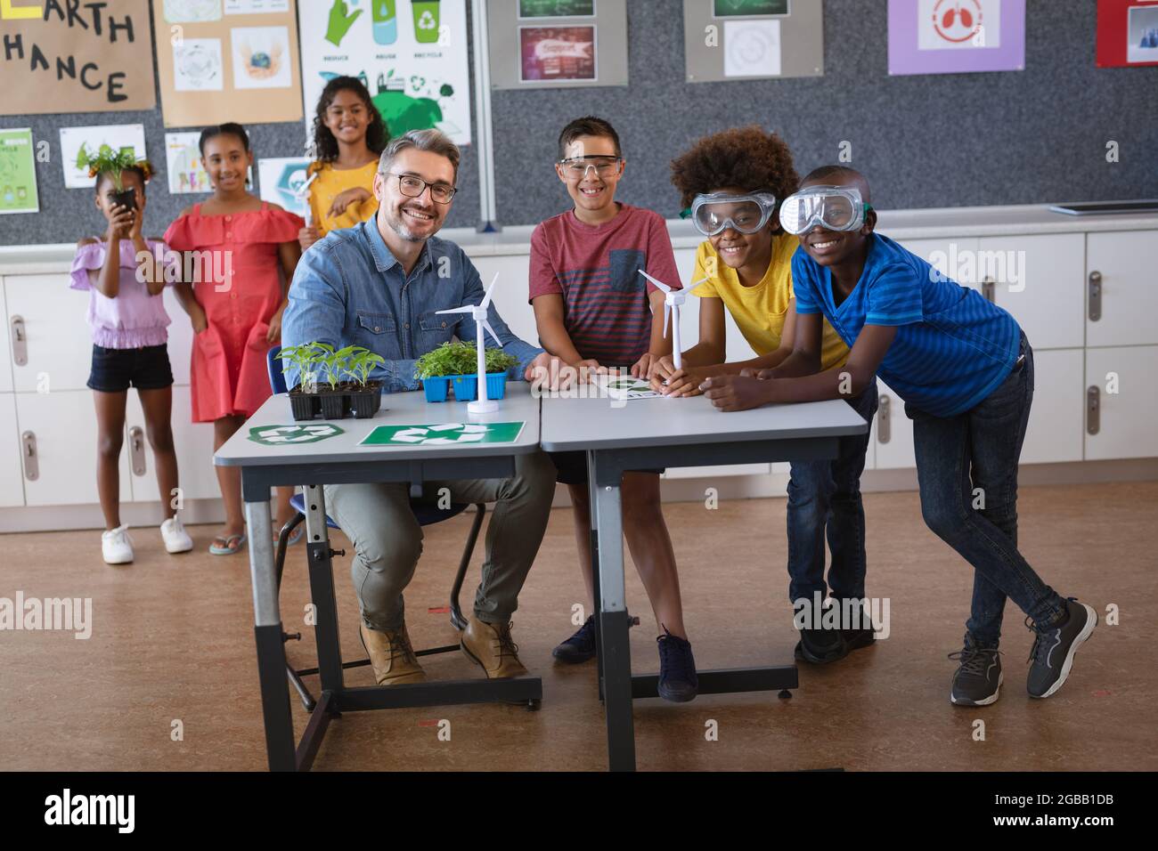 Ritratto di insegnante di sesso maschile caucasico e gruppo di ragazzi  diversi sorridenti durante la lezione di ambiente Foto stock - Alamy