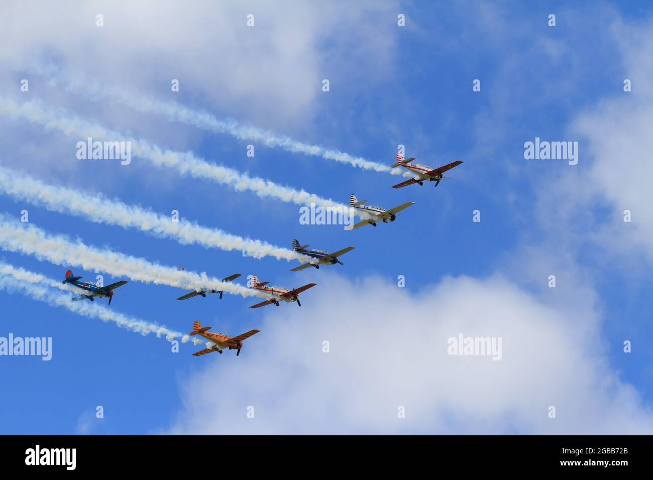 Una squadra aerobatica di Yakovlev Yak-52s, ex velivolo dell'allenatore sovietico, fumo di coda nel cielo Foto Stock