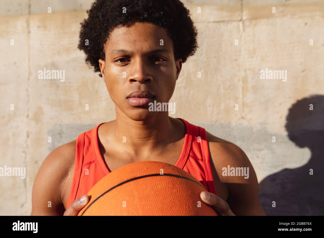 Ritratto dell'uomo afro-americano che si esercita in città tenendo il basket in strada Foto Stock