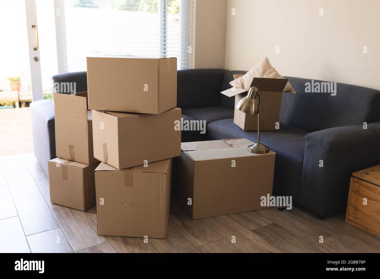 Pila di scatole preparate prima di spostare casa accanto al divano Foto Stock