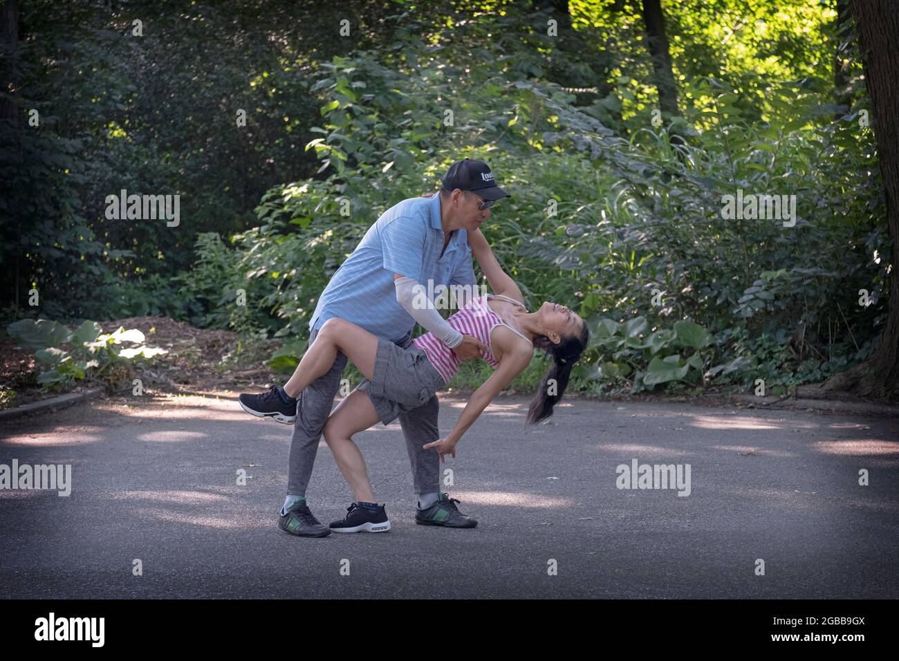 Una bella coppia asiatica americana di mezza età danza rigorosamente in una mattinata estiva nel 2021. A Queens, New York City. Foto Stock